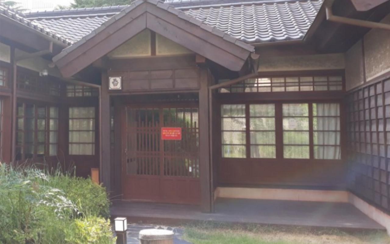 기와지붕과 목조 출입문, 마당이 보이는 봄 객실 외관 전경