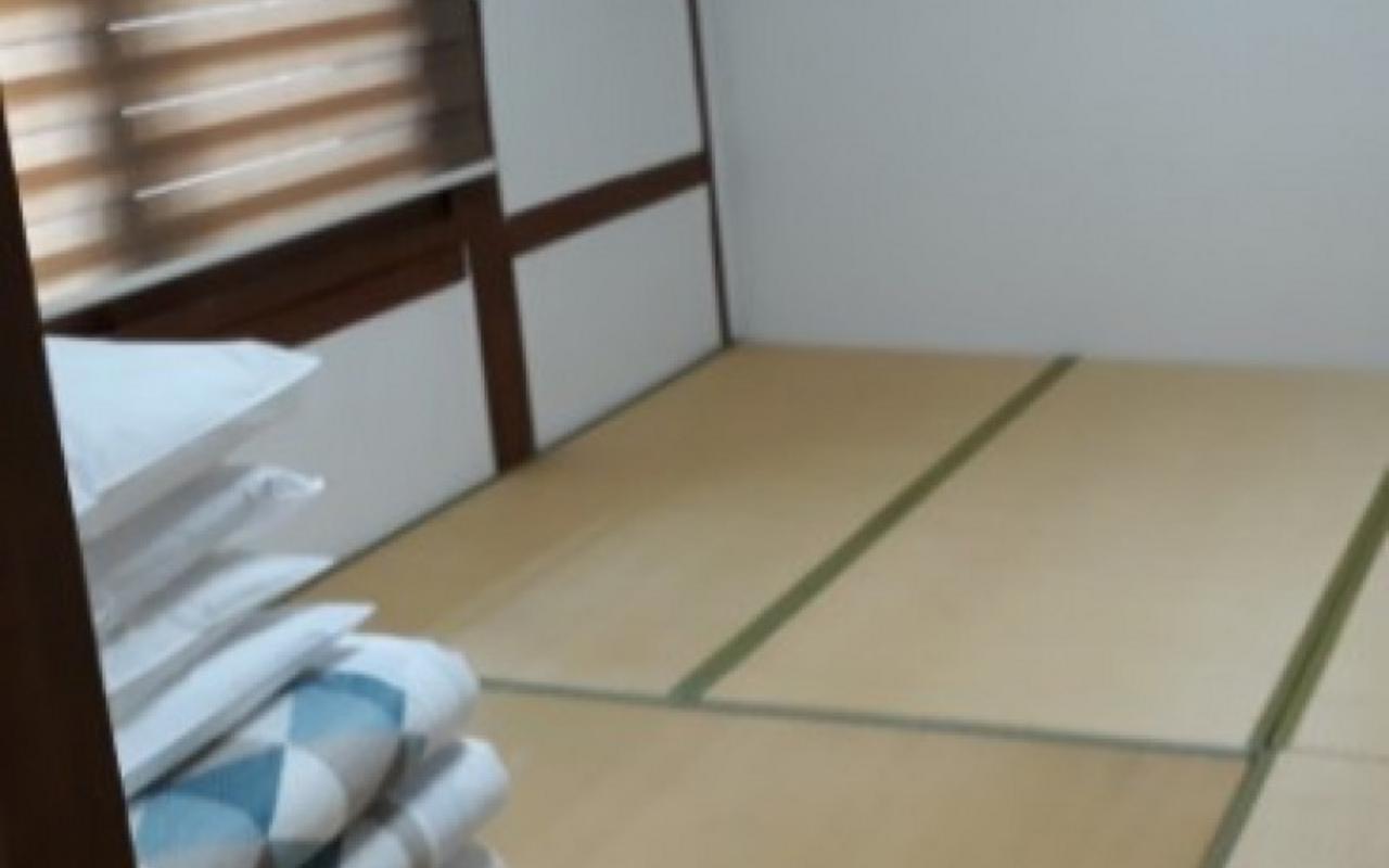 침구류가 한쪽에 개어져 있는 온돌형 침실 방 내부