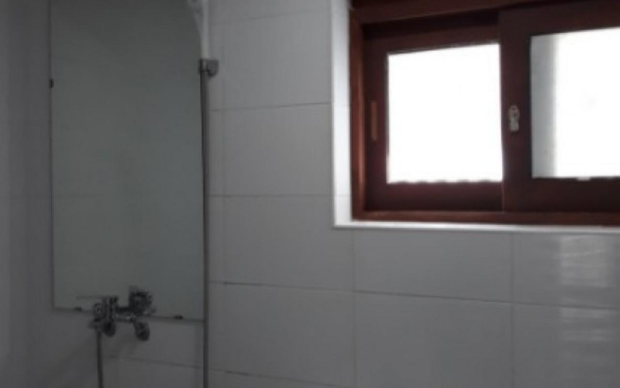 벽면 타일과 거울, 샤워 수전, 작은 창문이 있는 욕실